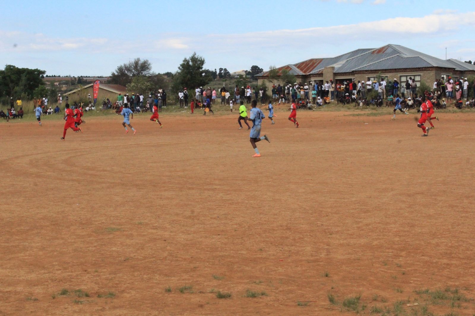 Live soccer match with spectators lining the field