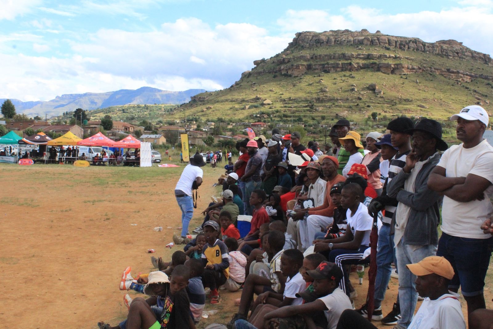 Crowd of supporters watching the tournament against a mountain backdrop