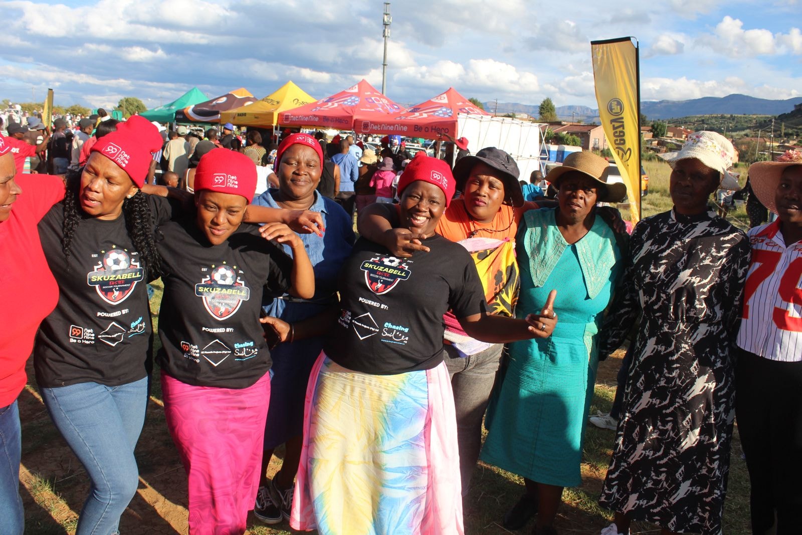 Women in Skuzabell shirts celebrating and dancing at the event