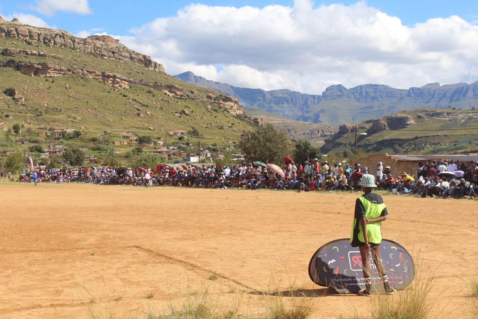 Large crowd watching a soccer match in a mountain valley